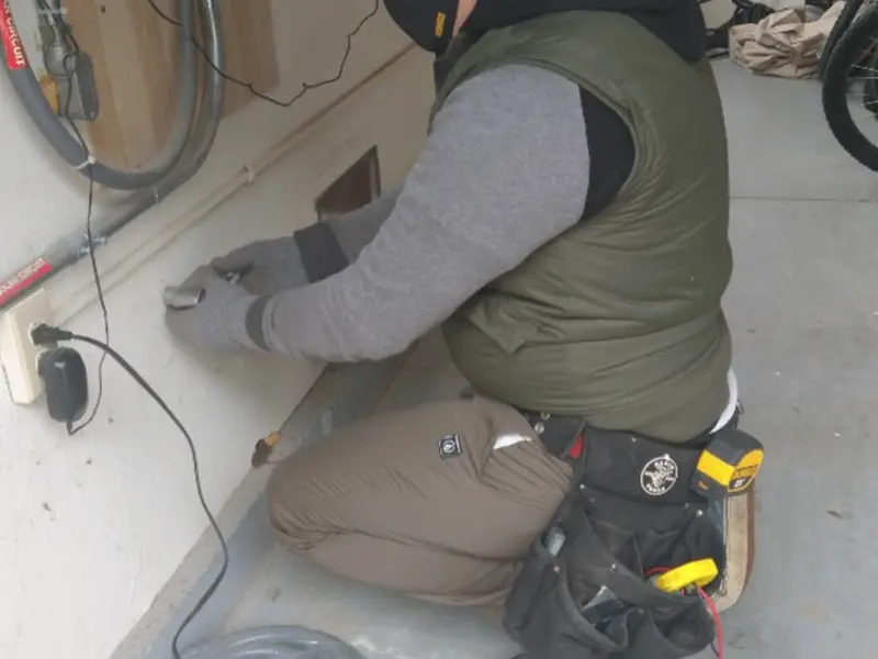 Electrician performing outlet wiring in a Kent garage